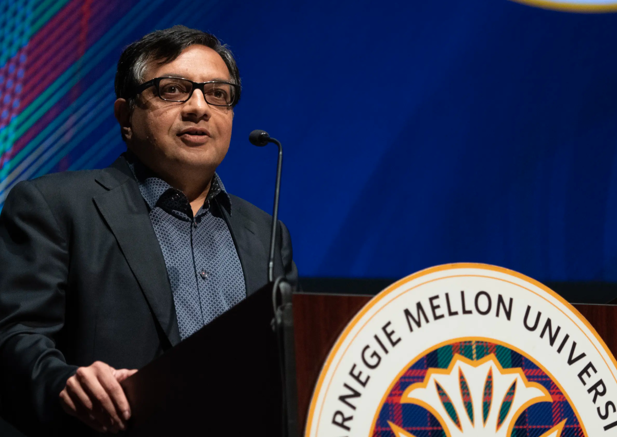 Sridhar Tayur speaking at a podium with the Carnegie Mellon University seal
